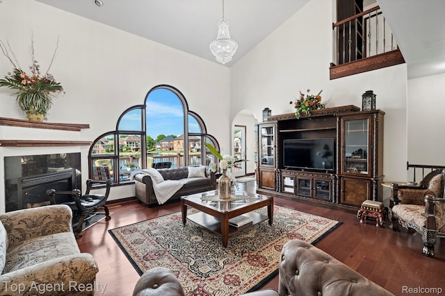 13205 Van Pamel Dr, Shelby Twp, MI 48315 - living area featuring arched walkways, high vaulted ceiling, wood finished floors, and a tiled fireplace