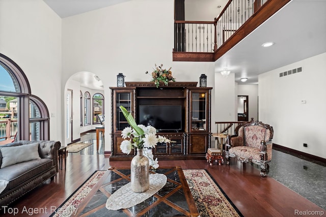 13205 Van Pamel Dr, Shelby Twp, MI 48315 - living room with arched walkways, a towering ceiling, and wood finished floors