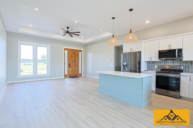 3973 W Harrison Rd, Hart, MI 49420 - kitchen with stainless steel appliances, backsplash, light countertops, light wood finished floors, and a kitchen island