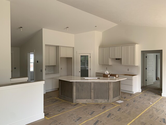 3094 Timberpine Ave, Holland, MI 49424 - kitchen with a kitchen island, high vaulted ceiling, and backsplash