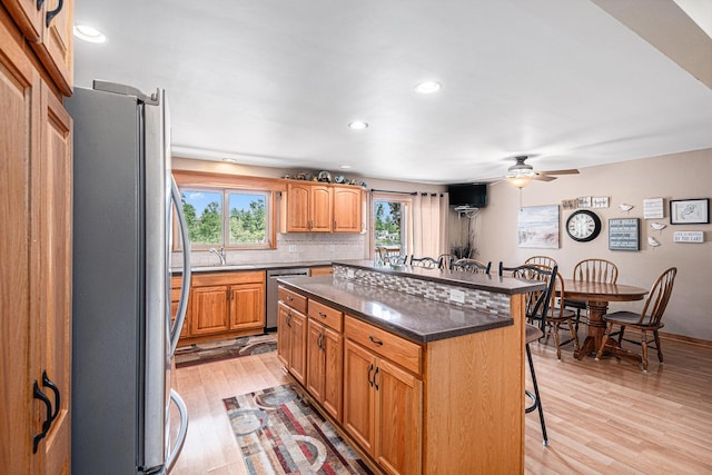 13278 W Stanton Rd, Trufant, MI 49347 - kitchen with stainless steel appliances, a kitchen bar, light wood-style floors, ceiling fan, and recessed lighting