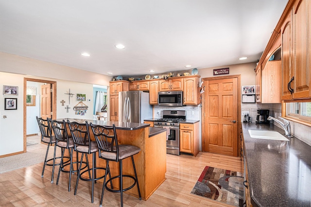 13278 W Stanton Rd, Trufant, MI 49347 - kitchen with stainless steel appliances, a kitchen breakfast bar, a center island, recessed lighting, and dark countertops