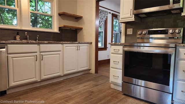 1020 N Monroe St, Lapeer, MI 48446 - kitchen with stainless steel appliances, backsplash, plenty of natural light, and wood finished floors