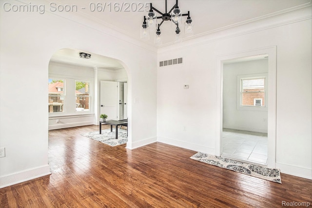 2701 Tuxedo St, Detroit, MI 48206 - empty room featuring arched walkways, healthy amount of natural light, ornamental molding, and wood finished floors