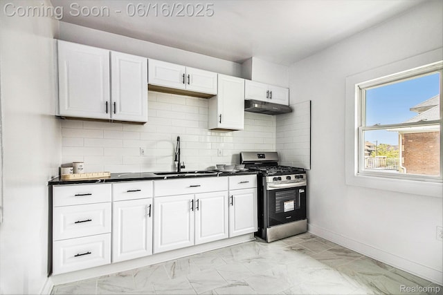 2701 Tuxedo St, Detroit, MI 48206 - kitchen featuring stainless steel range with gas cooktop, under cabinet range hood, dark countertops, light marble finish floors, and white cabinetry