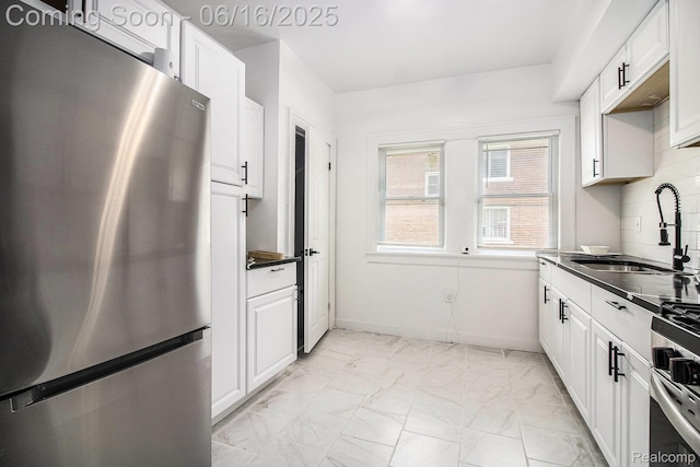 2701 Tuxedo St, Detroit, MI 48206 - kitchen featuring appliances with stainless steel finishes, light marble finish flooring, dark countertops, white cabinets, and tasteful backsplash