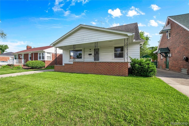 13513 Chestnut St, Southgate, MI 48195 - bungalow with a porch, a front lawn, brick siding, and a shingled roof