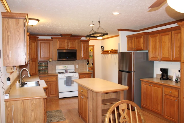 143 Tree Stand Rd, Rose City, MI 48654 - kitchen featuring appliances with stainless steel finishes, light countertops, light wood-style flooring, tasteful backsplash, and a center island