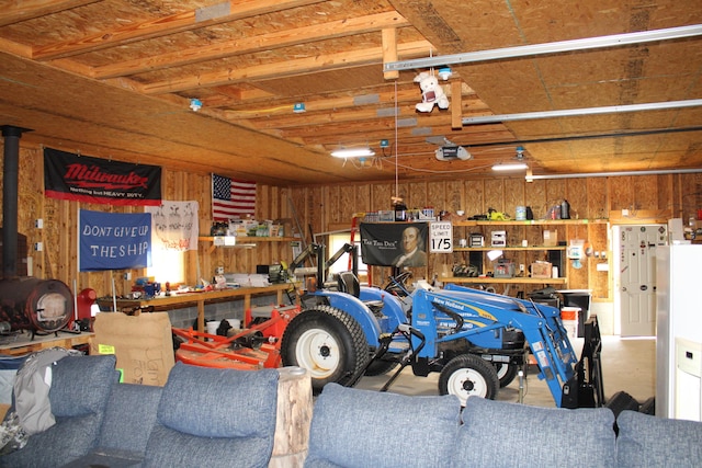 143 Tree Stand Rd, Rose City, MI 48654 - garage featuring a garage door opener, wooden walls, and a workshop area