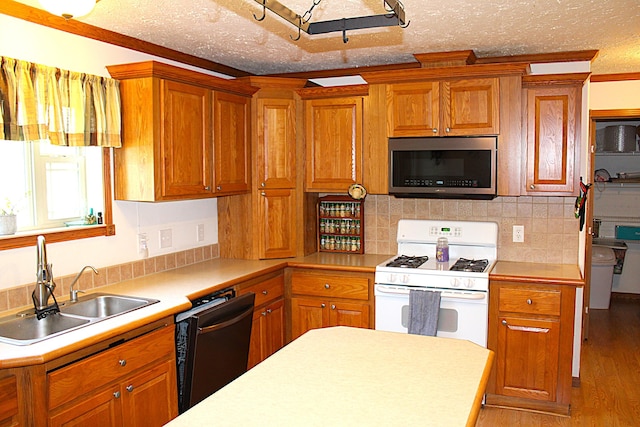 143 Tree Stand Rd, Rose City, MI 48654 - kitchen with stainless steel microwave, white gas stove, dishwasher, light countertops, and brown cabinetry