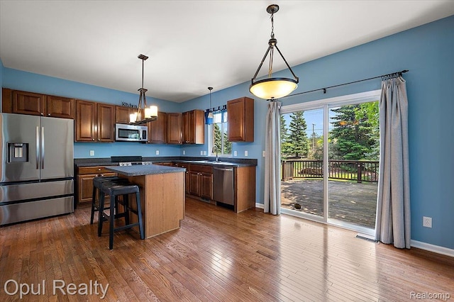 1978 Frances Way, Ypsilanti, MI 48198 - kitchen featuring appliances with stainless steel finishes, dark countertops, a kitchen island, a chandelier, and dark wood-style flooring