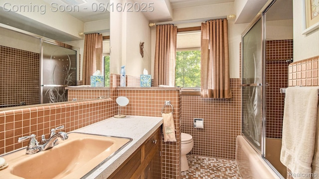 21556 Thorofare Rd, Trenton, MI 48138 - full bathroom featuring tile walls, enclosed tub / shower combo, vanity, a wainscoted wall, and tile patterned flooring