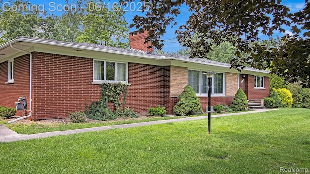 21556 Thorofare Rd, Trenton, MI 48138 - view of front of house with a chimney, brick siding, and a front yard