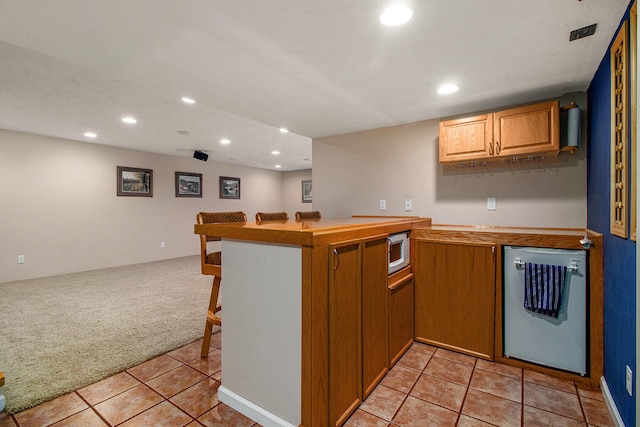 4497 Tiffany Ave, Portage, MI 49002 - kitchen with light colored carpet, stainless steel microwave, dishwashing machine, recessed lighting, and a breakfast bar area