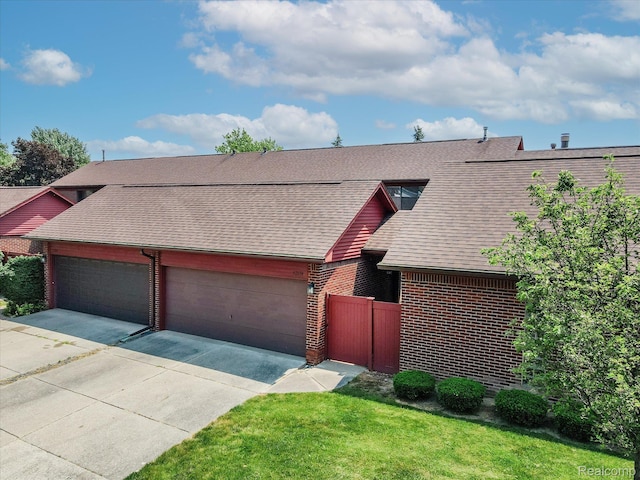 42134 Toddmark Ln, Clinton Township, MI 48038 - view of front of property with an attached garage, brick siding, a shingled roof, and driveway