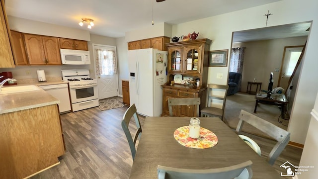 1107 Mccormick St, Monroe, MI 48162 - kitchen with white appliances, wood finished floors, light countertops, brown cabinetry, and glass insert cabinets