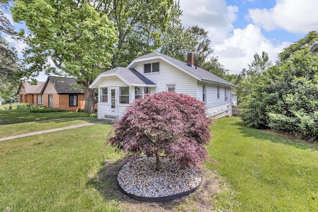 741 Lawrence St, Jackson, MI 49203 - view of front of property with a chimney, a front yard, and a shingled roof
