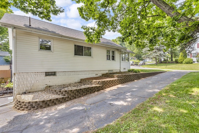 741 Lawrence St, Jackson, MI 49203 - view of side of home featuring a lawn and a shingled roof