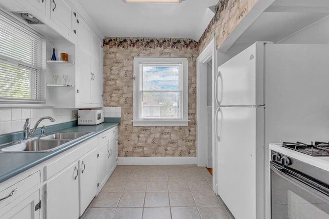 741 Lawrence St, Jackson, MI 49203 - kitchen featuring white cabinets, white microwave, gas range, open shelves, and wallpapered walls