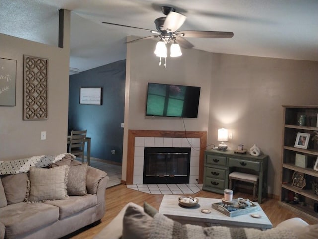 5664 Hall Rd, Muskegon, MI 49442 - living area featuring lofted ceiling, ceiling fan, light wood finished floors, and a tile fireplace