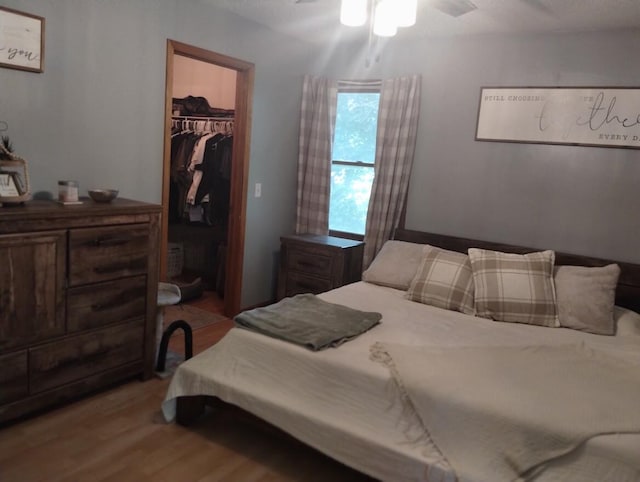 5664 Hall Rd, Muskegon, MI 49442 - bedroom featuring wood finished floors, a spacious closet, a closet, and a ceiling fan