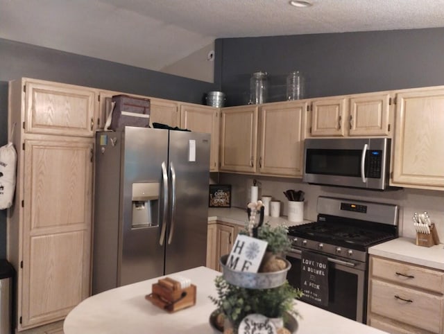 5664 Hall Rd, Muskegon, MI 49442 - kitchen featuring appliances with stainless steel finishes, light brown cabinets, light countertops, and lofted ceiling