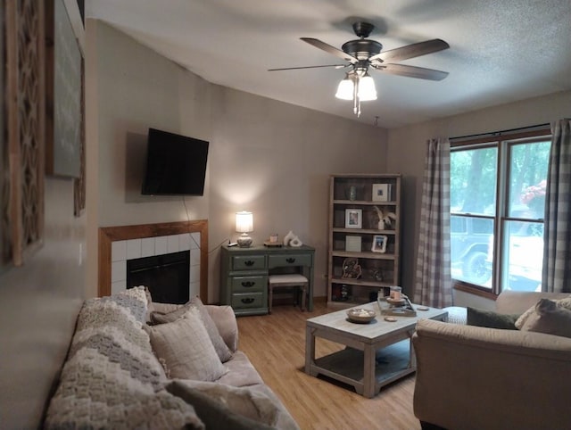 5664 Hall Rd, Muskegon, MI 49442 - living area with a tiled fireplace, ceiling fan, and light wood-style floors