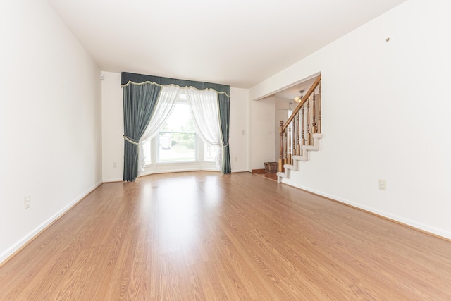 5835 S Ashford Way, Ypsilanti, MI 48197 - spare room with stairway and light wood finished floors