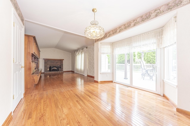 5835 S Ashford Way, Ypsilanti, MI 48197 - unfurnished living room featuring light wood-type flooring, a brick fireplace, a chandelier, and lofted ceiling