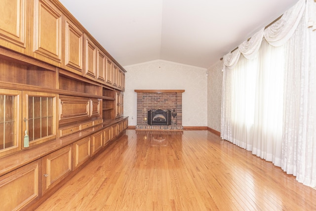 5835 S Ashford Way, Ypsilanti, MI 48197 - unfurnished living room featuring vaulted ceiling, light wood-type flooring, and a brick fireplace