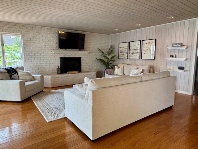 68121 Edgewater Beach Rd, White Pigeon, MI 49099 - living room with wooden ceiling, a fireplace, wood walls, wood finished floors, and brick wall