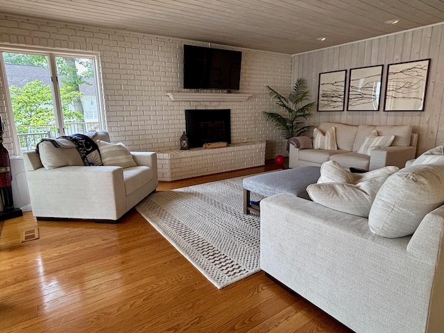 68121 Edgewater Beach Rd, White Pigeon, MI 49099 - living room featuring light wood-type flooring, a brick fireplace, wood walls, and wooden ceiling