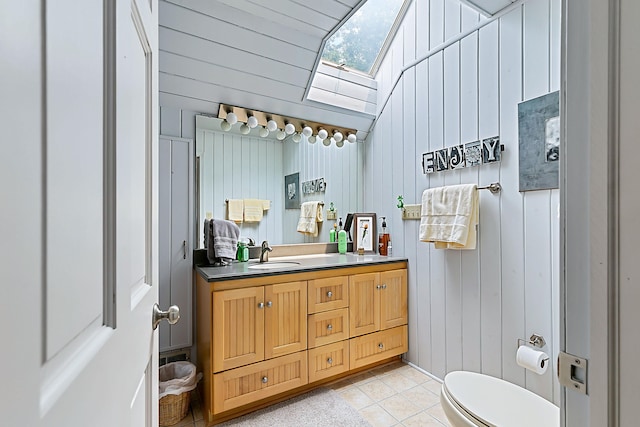 68121 Edgewater Beach Rd, White Pigeon, MI 49099 - bathroom with a skylight, vanity, tile patterned flooring, wooden walls, and vaulted ceiling