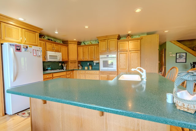 7111 Gilbert Rd, Pittsford, MI 49271 - kitchen featuring white appliances, recessed lighting, tasteful backsplash, light wood-style floors, and a kitchen breakfast bar