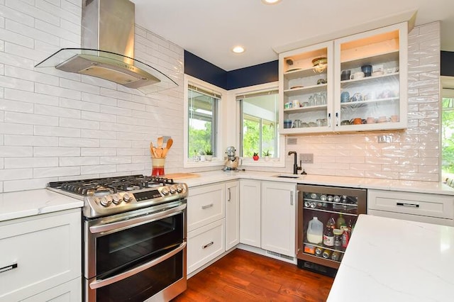 5284 Green Pine Ln, Kalamazoo, MI 49009 - kitchen featuring double oven range, wall chimney range hood, backsplash, glass insert cabinets, and recessed lighting
