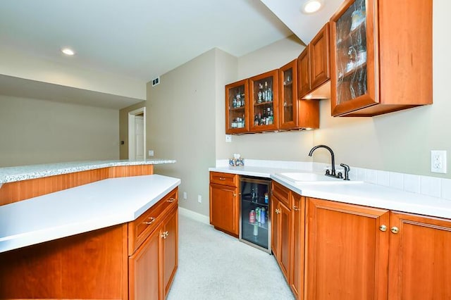 5284 Green Pine Ln, Kalamazoo, MI 49009 - kitchen with wine cooler, light colored carpet, light countertops, brown cabinetry, and recessed lighting