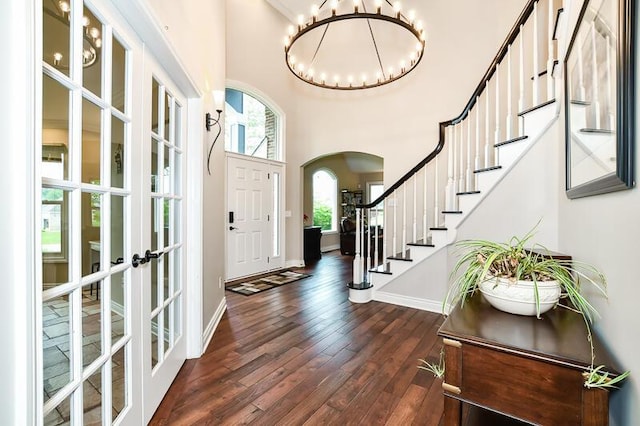 5284 Green Pine Ln, Kalamazoo, MI 49009 - entrance foyer with arched walkways, dark wood-type flooring, stairway, a chandelier, and french doors