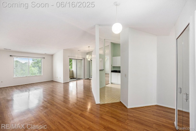 6700 Ridgefield Cir Unit 201, West Bloomfield, MI 48322 - spare room with wood finished floors and vaulted ceiling