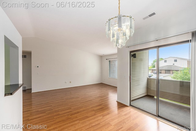 6700 Ridgefield Cir Unit 201, West Bloomfield, MI 48322 - empty room with a chandelier, light wood-type flooring, and lofted ceiling