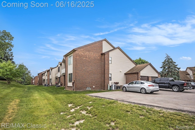 6700 Ridgefield Cir Unit 201, West Bloomfield, MI 48322 - view of home's exterior featuring a lawn and brick siding