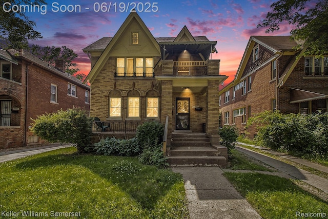 14551 Mettetal, Detroit, MI 48227 - tudor home featuring a balcony, covered porch, brick siding, and a front yard