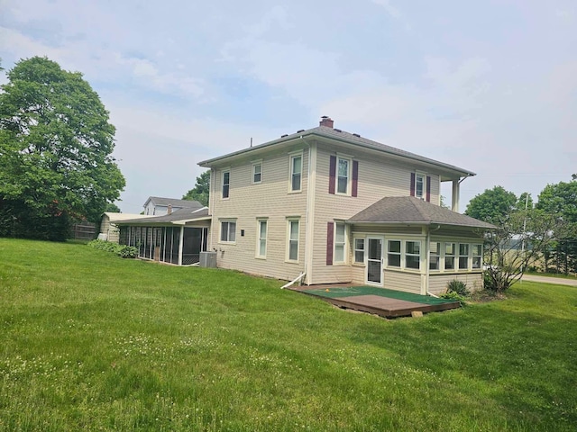 20051 Capital Ave NE, Battle Creek, MI 49017 - rear view of property featuring a sunroom, a lawn, a wooden deck, and a chimney