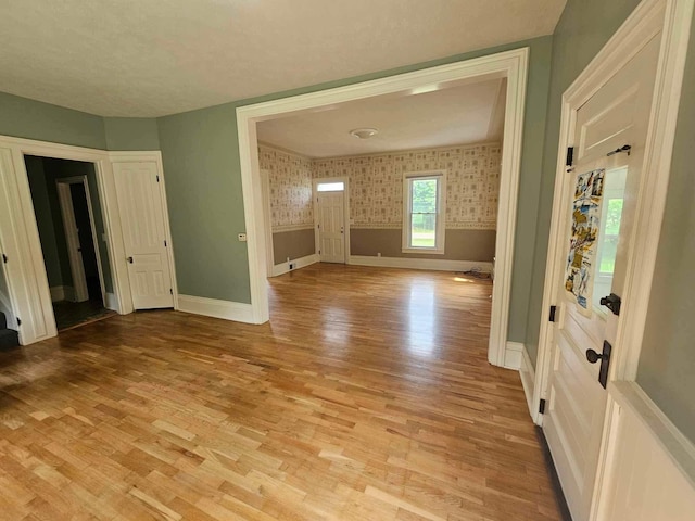 20051 Capital Ave NE, Battle Creek, MI 49017 - unfurnished living room with light wood-style flooring, wallpapered walls, and a wainscoted wall