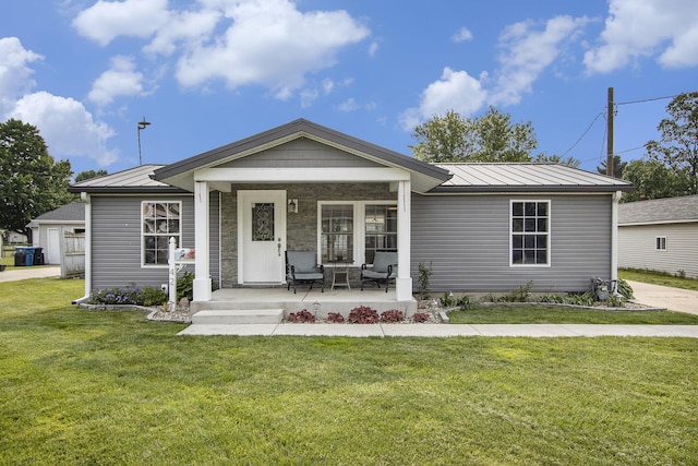 42 S 25th St, Battle Creek, MI 49015 - ranch-style home featuring covered porch, a standing seam roof, a front yard, and a metal roof