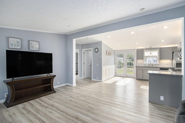 42 S 25th St, Battle Creek, MI 49015 - living room with light wood-style floors, crown molding, recessed lighting, french doors, and a textured ceiling