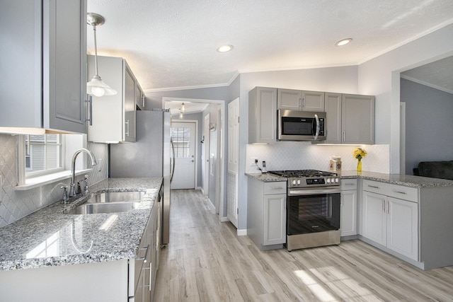 42 S 25th St, Battle Creek, MI 49015 - kitchen with appliances with stainless steel finishes, ornamental molding, gray cabinetry, decorative backsplash, and light wood finished floors