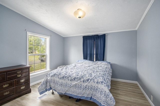 42 S 25th St, Battle Creek, MI 49015 - bedroom featuring a textured ceiling, vaulted ceiling, light wood finished floors, and ornamental molding