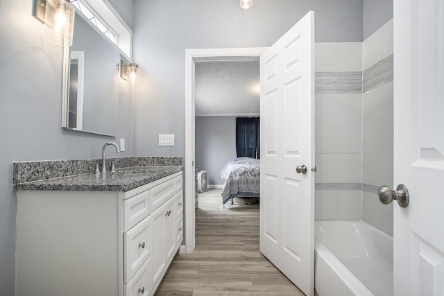 42 S 25th St, Battle Creek, MI 49015 - bathroom featuring vanity, wood finished floors, ensuite bathroom, and bathtub / shower combination