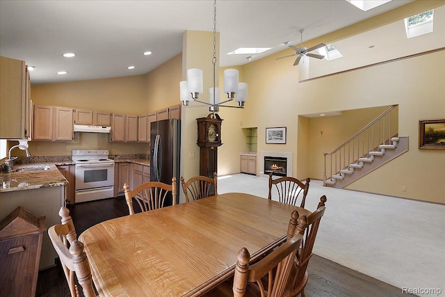 55728 Lorraine Dr Unit 20, Utica, MI 48316 - dining room featuring high vaulted ceiling, a skylight, a lit fireplace, stairway, and recessed lighting