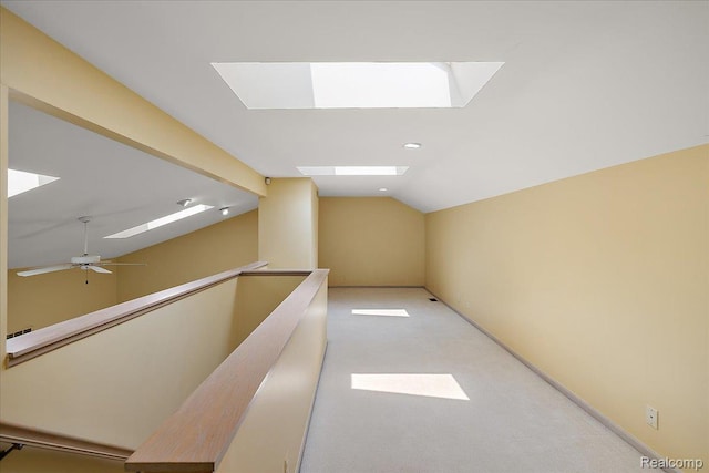 55728 Lorraine Dr Unit 20, Utica, MI 48316 - hallway featuring a skylight, vaulted ceiling, and light carpet